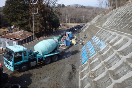 法面工事の様子です。道路にはタンクローリーが止まっています。