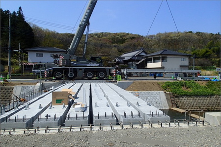橋の床版の工事の様子です。クレーン車を用いて作業しています。