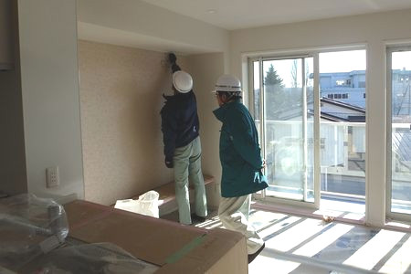 当財団職員が内部の仕上げを確認しています。床はシートで養生されています。