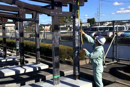 当財団職員が鉄骨の検査をしています。コンベックスを当てて寸法を測っています。